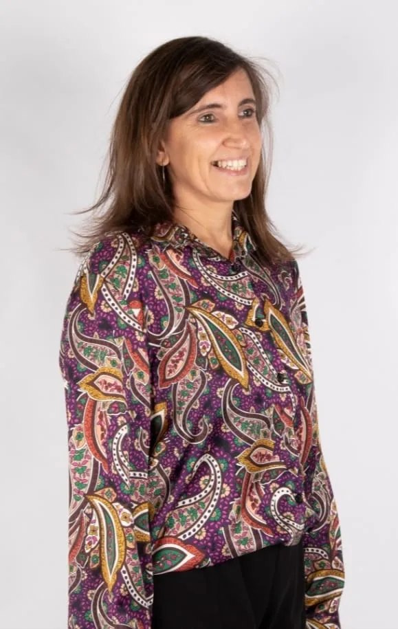 Alícia Expósito, dempeus, somrient, amb una brusa estampada.