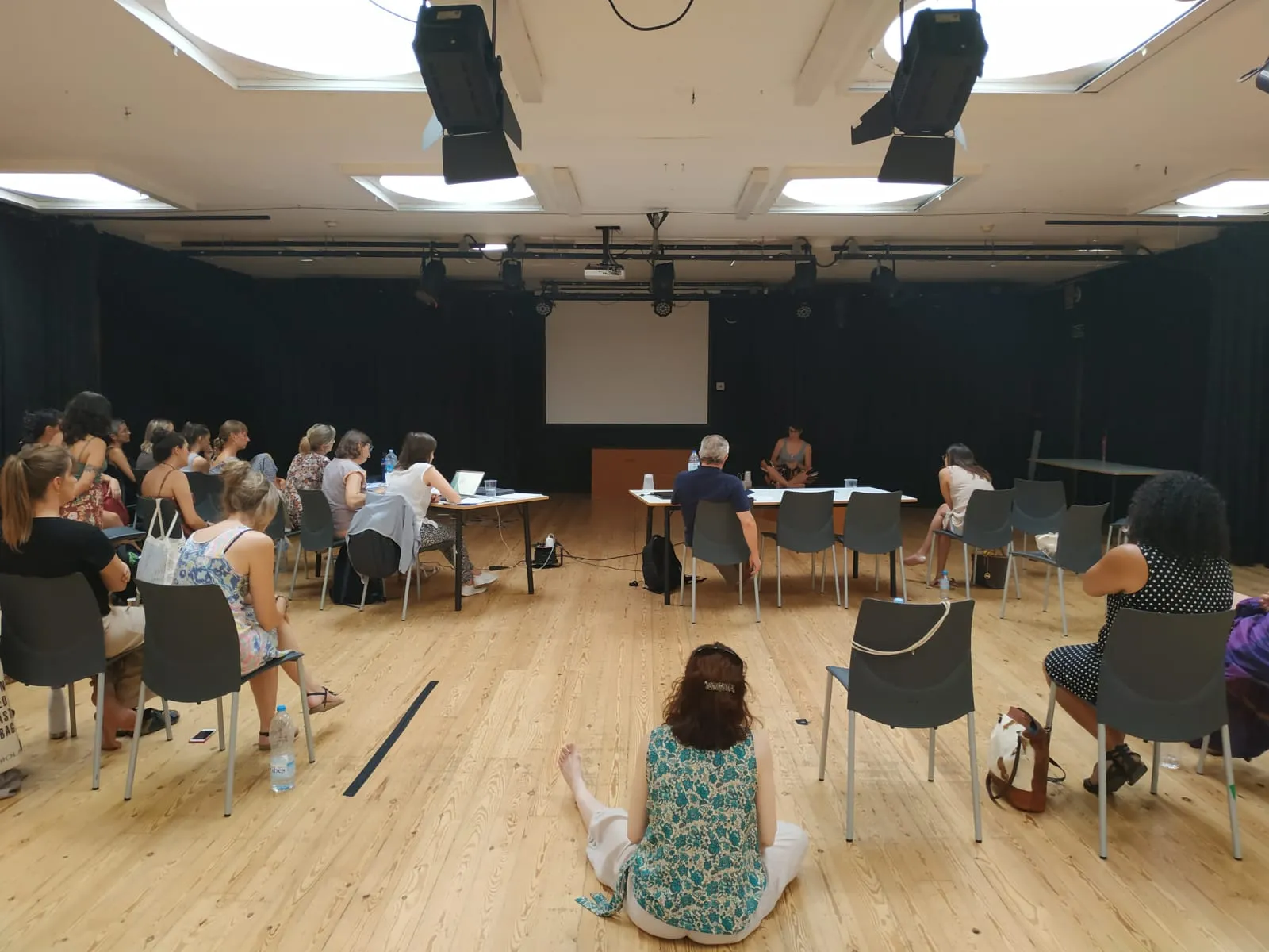 Alumnes del màster en rotllana en un auditori, durant una presentació.