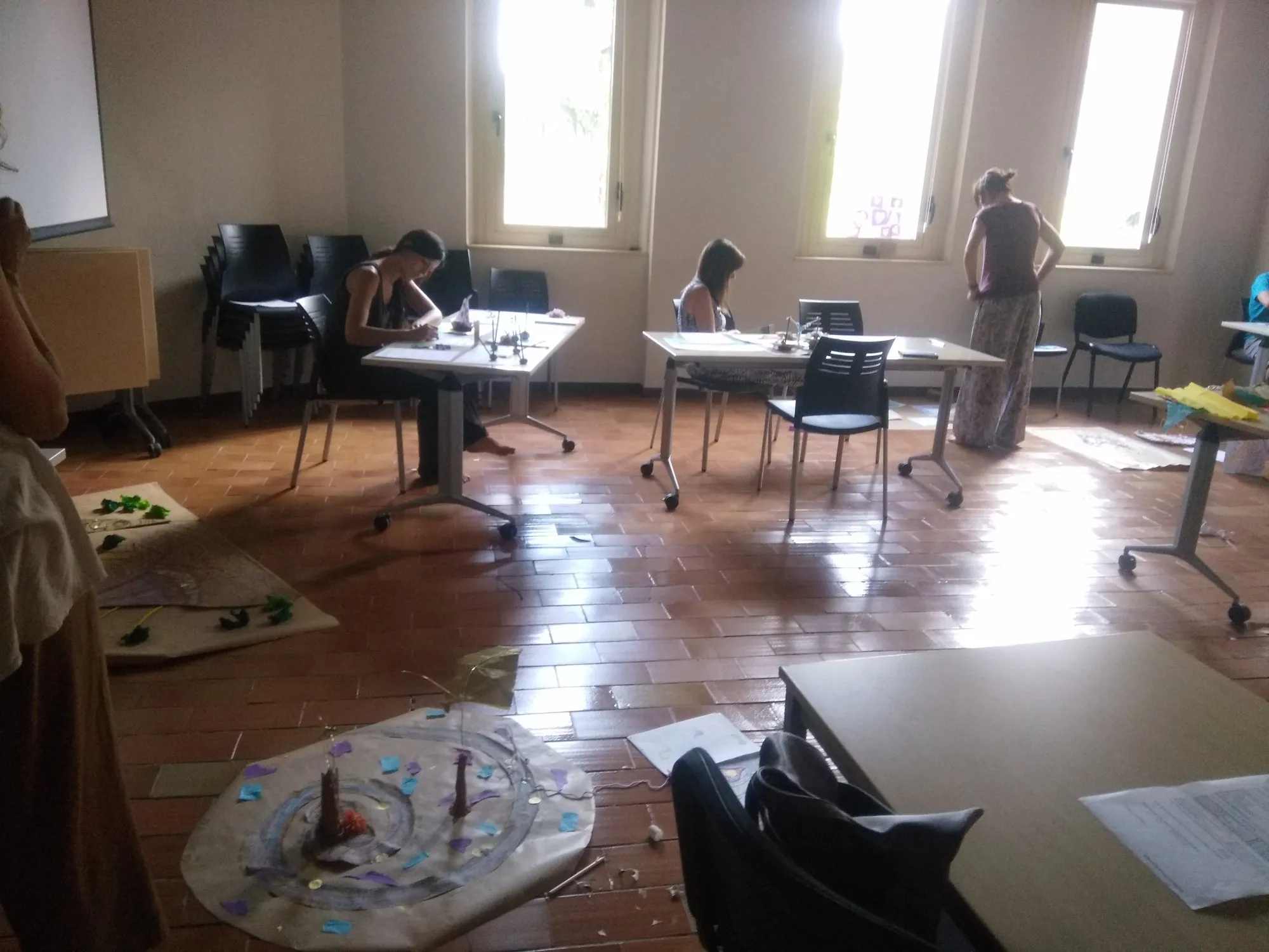 Creacions amb materials diversos sobre el terra de la sala del curs d'estiu.