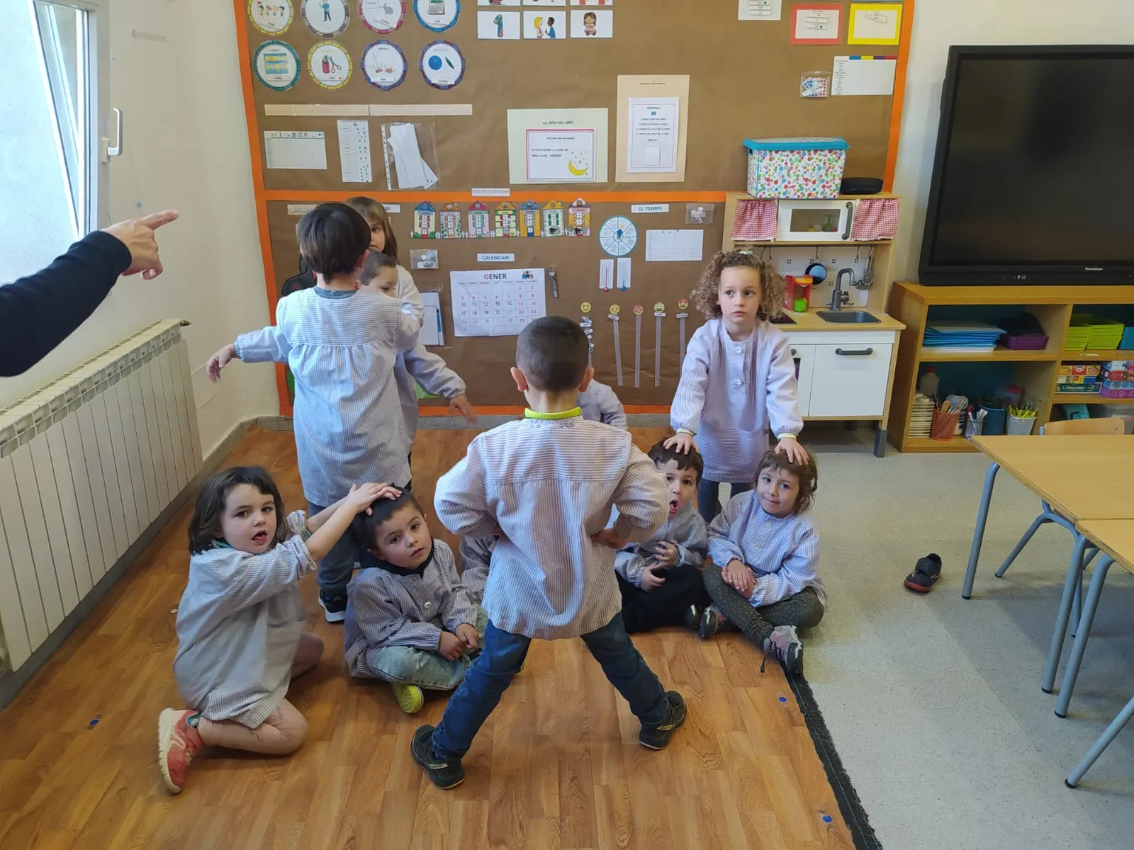 Grup d'infants amb bates fent una escultura amb el cos d'un company.