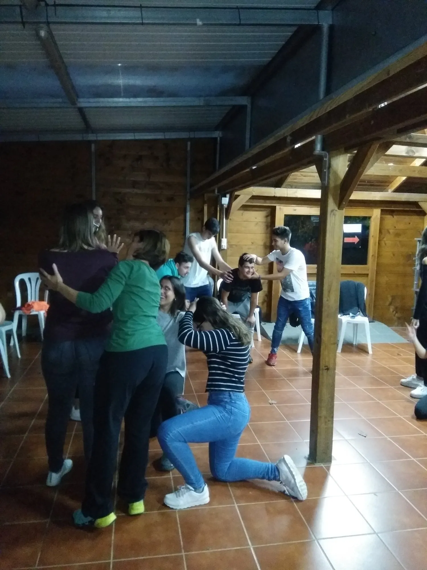 Alumnes treballant en parella amb el cos, en una sala amb bigues de fusta.