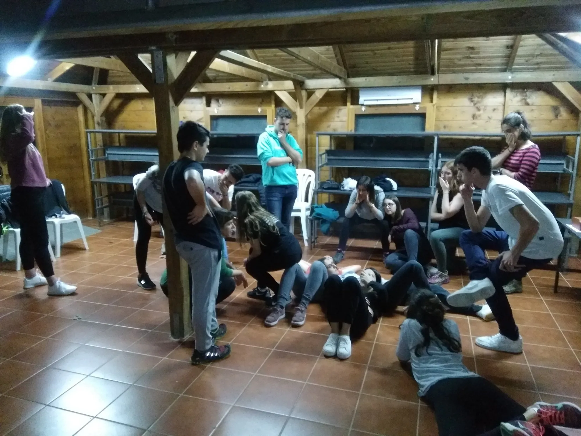 Alumnes en moviment pel terra de la sala durant el taller de sensibilització.