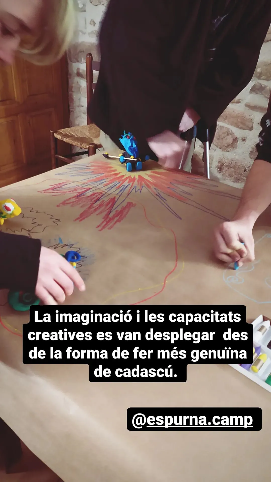 Mans dibuixant sobre un paper gran. Text: «La imaginació i les capacitats creatives es van desplegar des de la forma de fer més genuïna de cadascú».